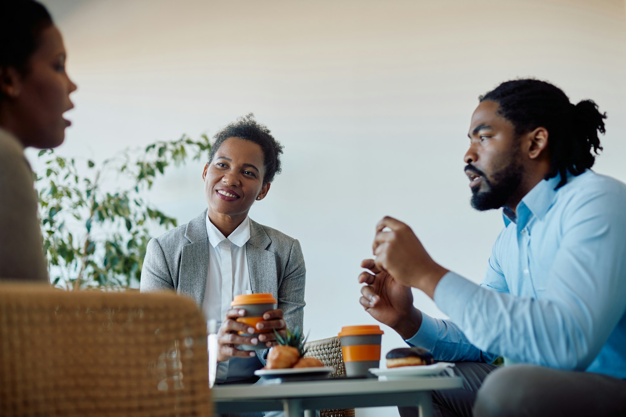 Group of black colleagues communicating during their coffee break in the office.